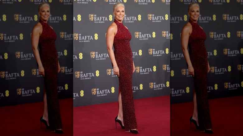 Hannah Waddingham porte une robe rouge scintillante qui laisse apparaître ses talons noirs avec une fente arrière