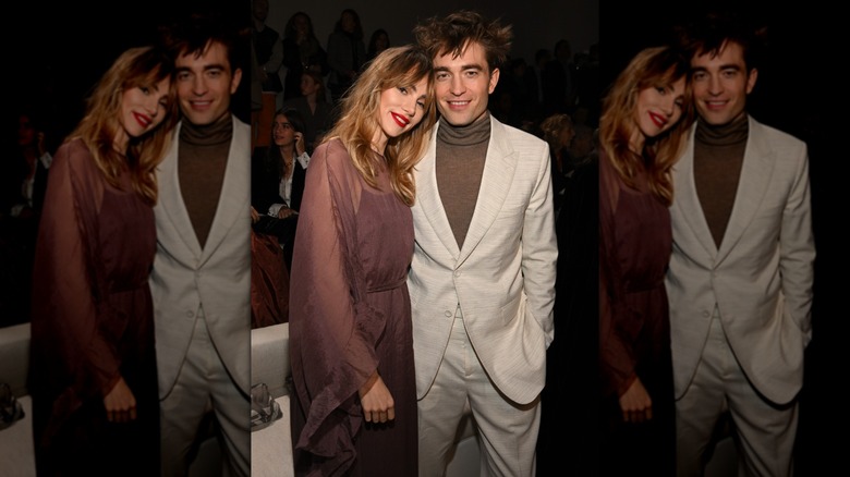 Suki Waterhouse appuyée contre un Robert Pattinson souriant lors de la collection Dior homme automne 2023