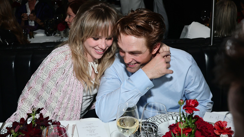 Suki Waterhouse et Robert Patinson rient en penchant la tête l'une contre l'autre lors d'un dîner de remise de prix