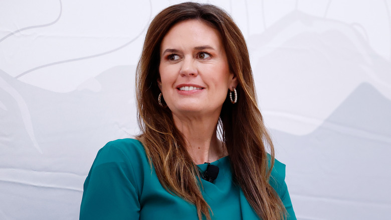 Sarah Huckabee Sanders vêtue de vert et regardant sur le côté