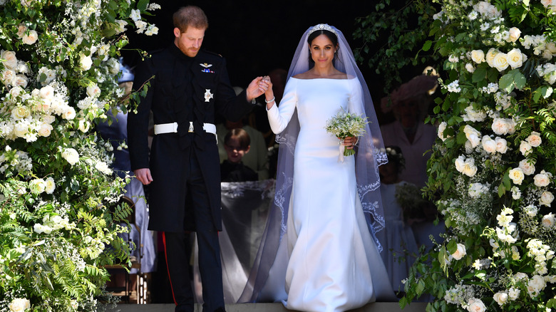 Meghan Markle se tient à côté du prince Harry, vêtue d'une robe de mariée à col ouvert