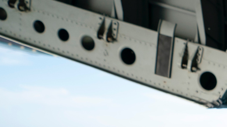 Kristi Noem assise dans la porte cargo arrière ouverte d'un C-130 de la Garde côtière américaine