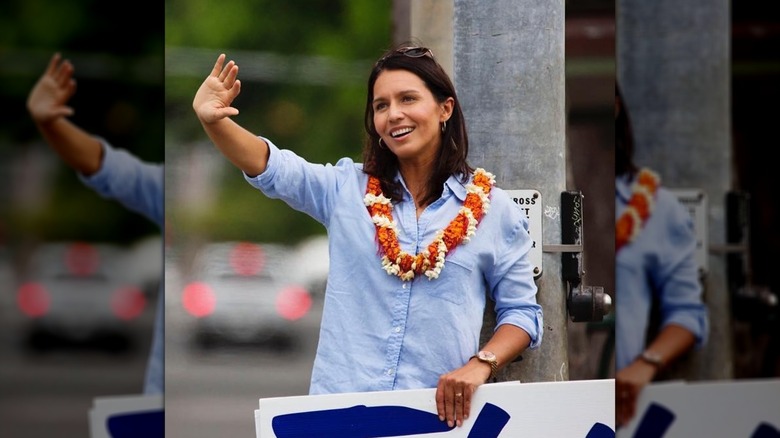 Tulsi Gabbard agitant la main en août 2016, portant une chemise et un collier