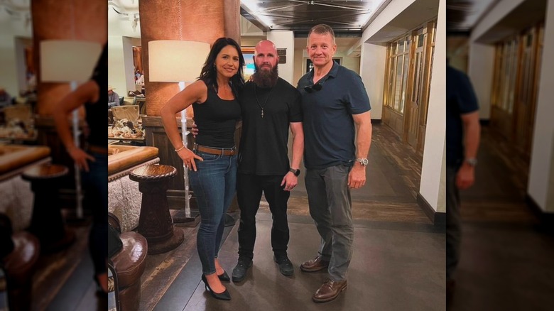 Tulsi Gabbard posant pour une photo avec deux hommes en avril 2024