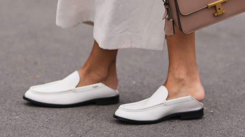 Une femme portant une paire de mocassins blancs sans noir