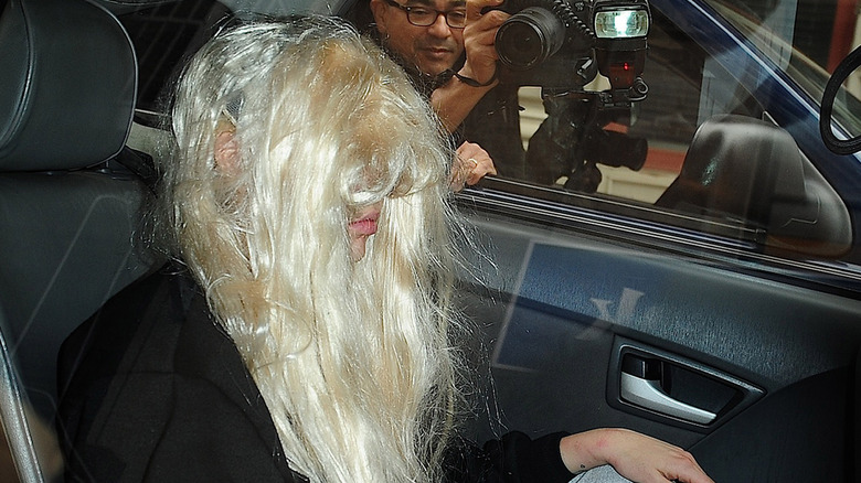 Amanda Bynes se couvre le visage avec une perruque blonde