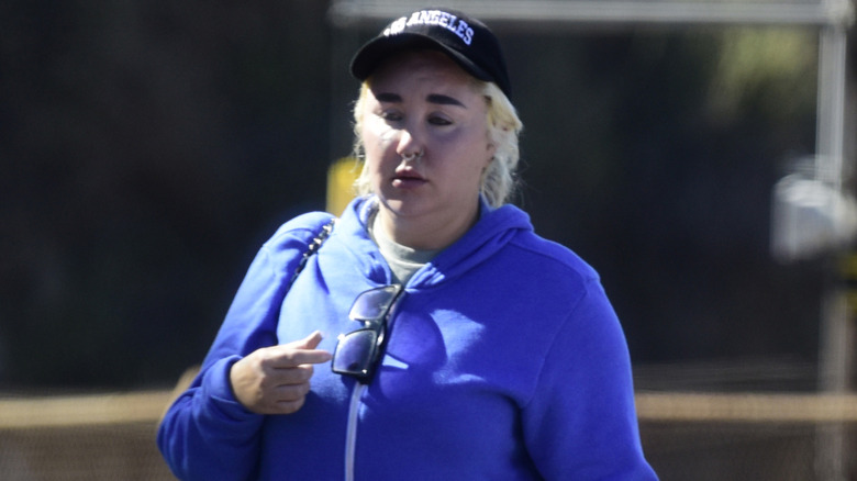 Amanda Bynes marche avec une casquette et des cheveux blonds