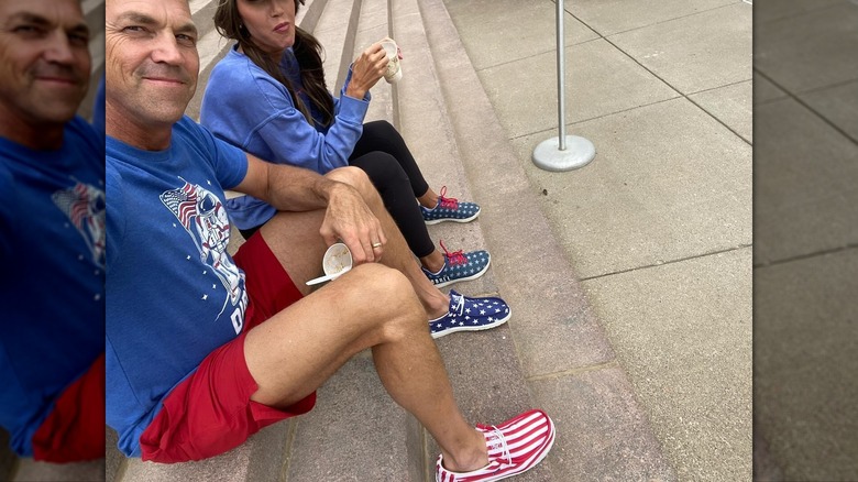 Bryon Noem et Kristi Noem assis ensemble sur les marches pendant qu'il sourit et que sa tête est coupée sur l'image