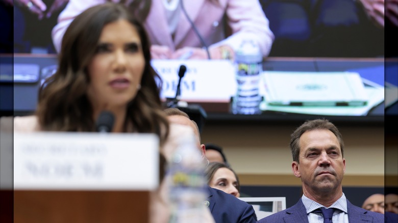 Bryon Noem assis derrière Kristi Noem, dont le visage est flou