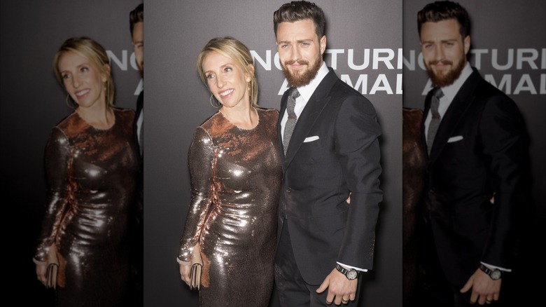 Sam Taylor-Johnson se tient dans une robe argentée à côté d'Aaron Taylor-Johnson fronce les sourcils