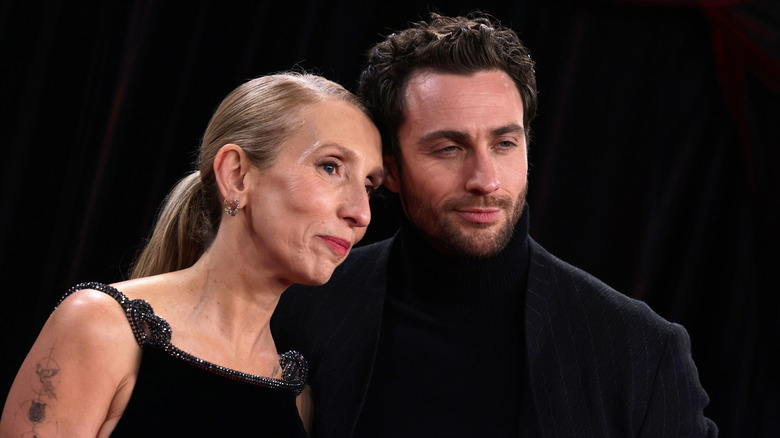 Sam Taylor-Johnson porte ses cheveux lissés en arrière et se tient à côté d'Aaron Taylor-Johnson en feu