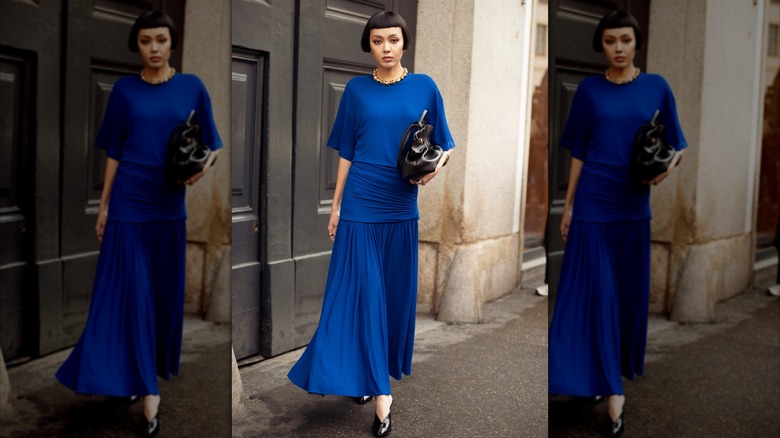 Une femme vêtue d'une robe drapée bleue