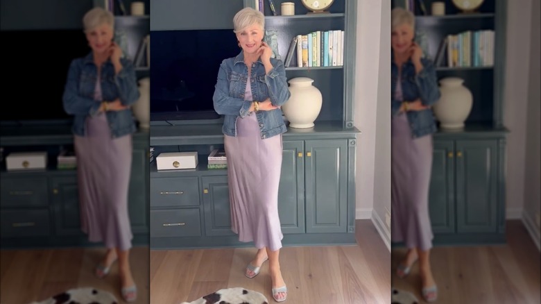 Une femme portant une robe nuisette en satin violet avec une veste en jean