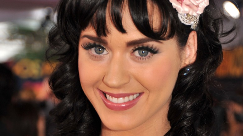 Katy Perry souriante sur le tapis rouge en 2008 avec une peau bronzée et mate