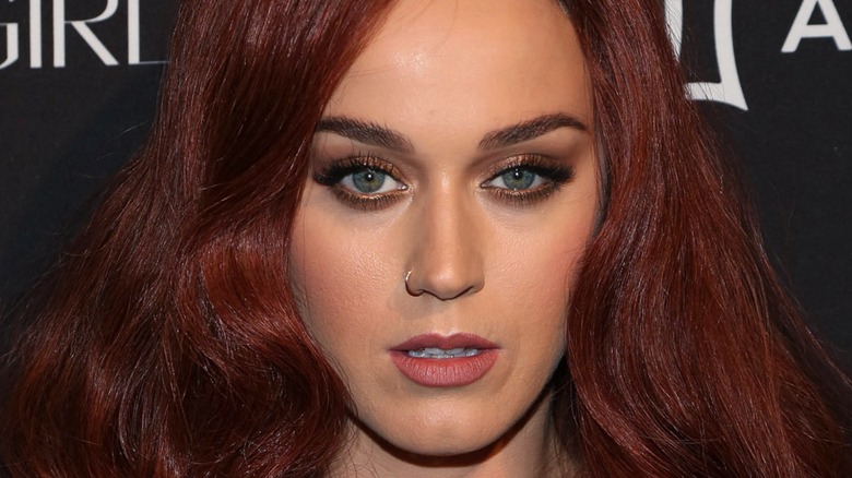 Katy Perry avec une expression sensuelle à la soirée Harper ICONS 2015 avec des cheveux roux foncé