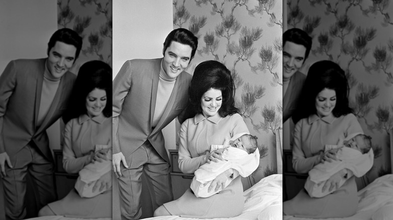 Elvis Presley se tient à côté de Priscilla Presley tenant Lisa Marie
