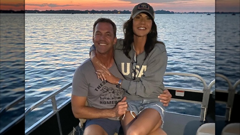 Kristi Noem assise sur les genoux de Bryon Noem sur un bateau