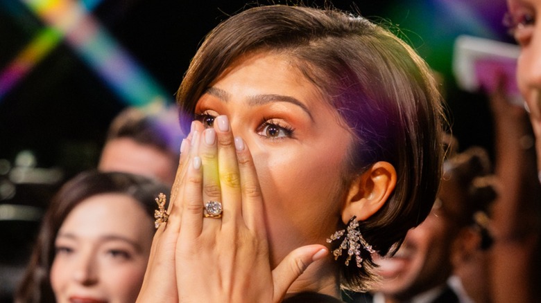 Zendaya avec ses mains sur sa bouche, montrant sa bague de fiançailles et son éventuelle alliance, aux Oscars 2026
