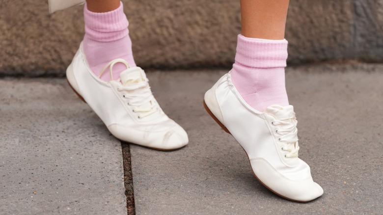 Une femme portant des chaussures sneakerina avec des chaussettes roses