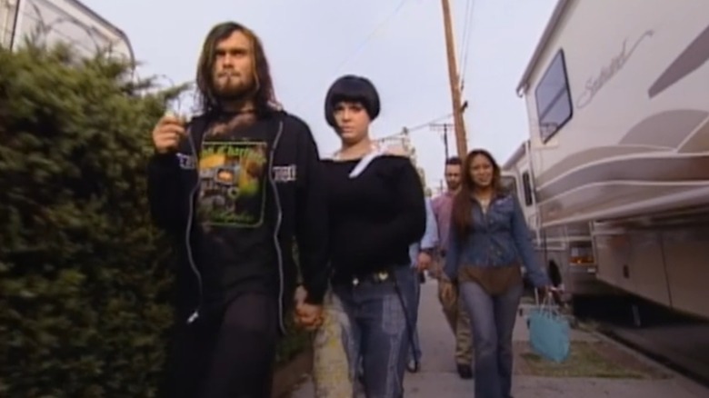 Bert McCracken tenant la main de Kelly Osbourne alors qu'ils marchent sur le trottoir avec un groupe de personnes