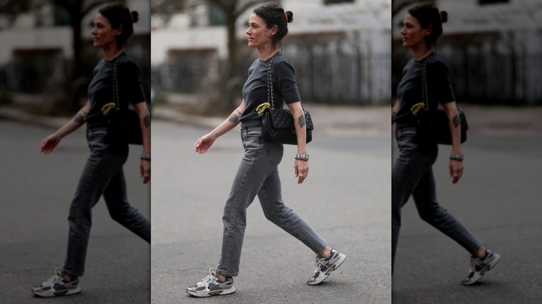 Une femme portant un jean skinny gris avec un t-shirt noir