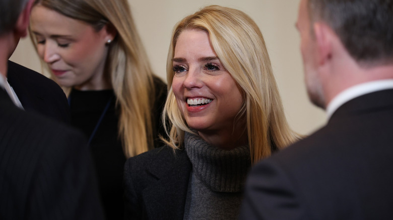 Pam Bondi sourit en parlant à des collègues lors d'un événement