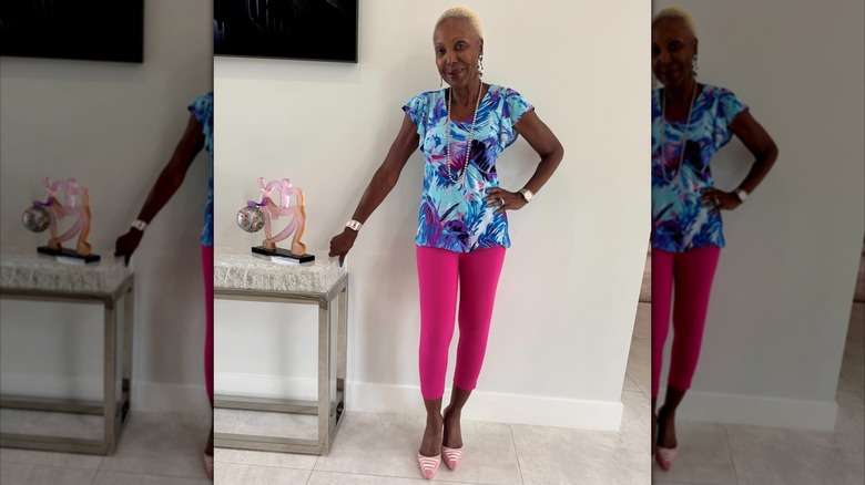 Une femme portant un pantacourt rose et un haut bleu à motifs