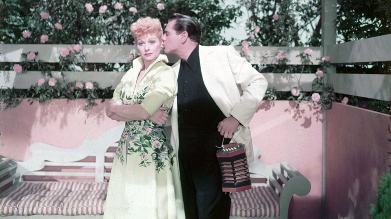 Lucille Ball embrassée sur la joue par Desi Arnaz dans une roseraie