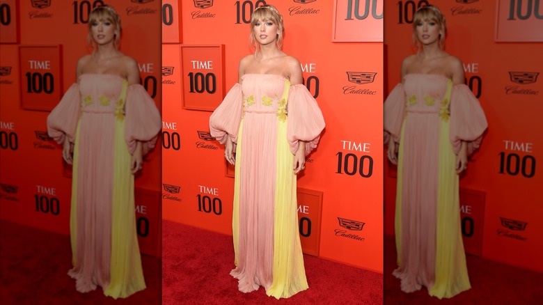 Taylor Swift dans une robe rose et jaune sur le tapis rouge du Time 100 Gala