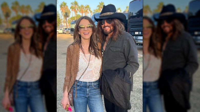 Elizabeth Hurley debout à côté de Billy Ray Cyrus en plein air