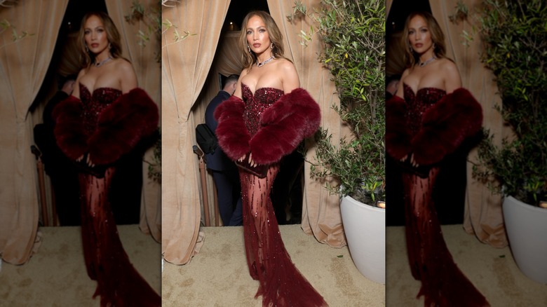 Jennifer Lopez dans une robe rouge vin scintillante avec un manteau de fourrure assorti