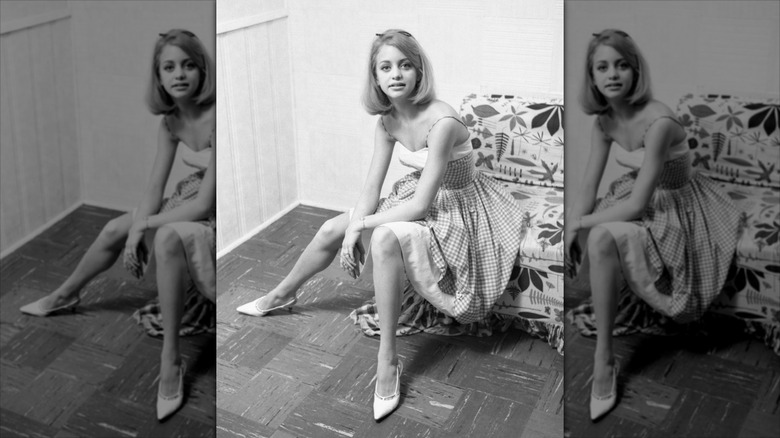 Goldie Hawn porte des talons blancs pointus et une robe à carreaux vichy.