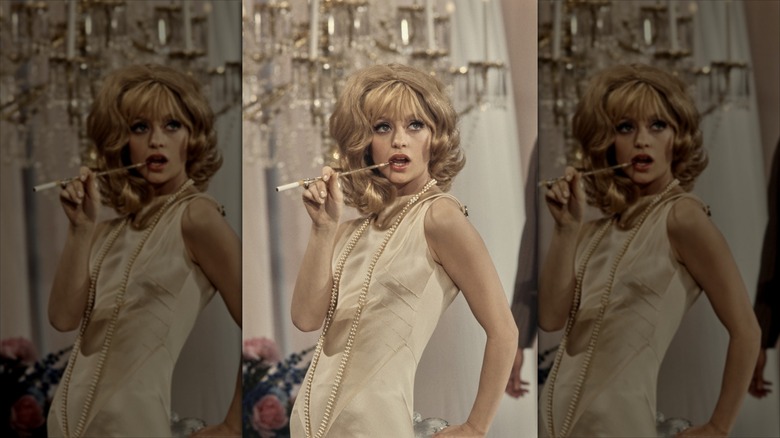 Goldie Hawn pose avec un rallonge de cigarette et une coiffure bouffante
