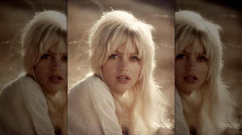 Goldie Hawn pose avec des cheveux blond platine en désordre