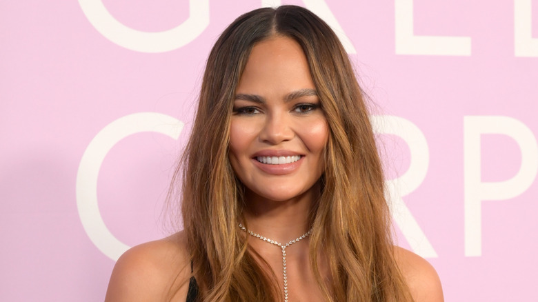 Chrissy Teigen sur le tapis rouge en souriant