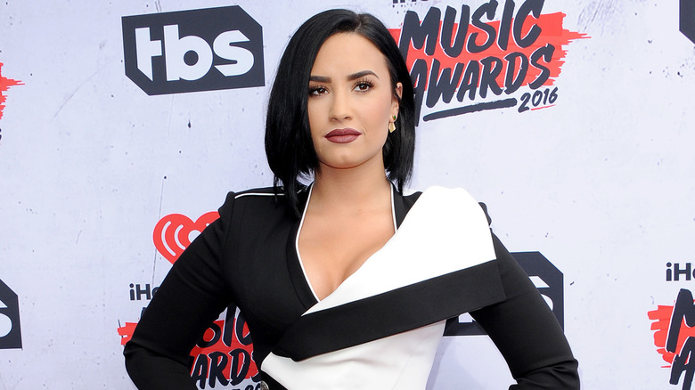 Demi Lovato sur le tapis rouge dans une robe noire et blanche