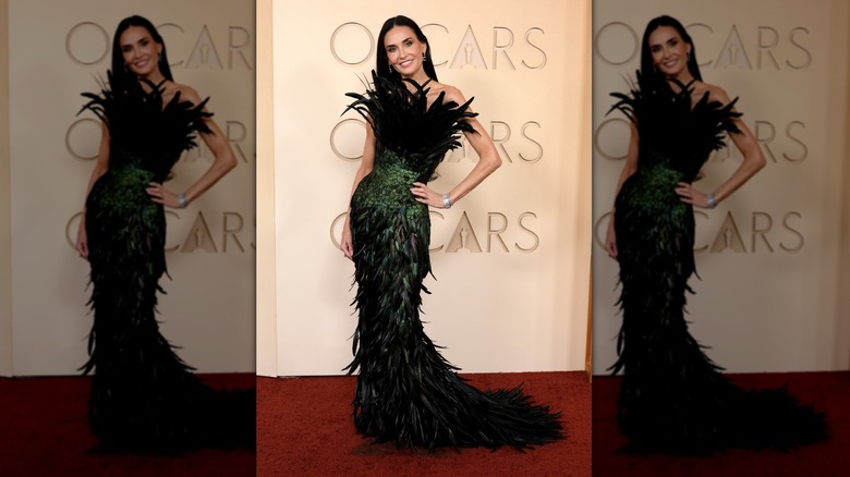 Demi Moore sur le tapis rouge dans une robe à plumes noires et vertes