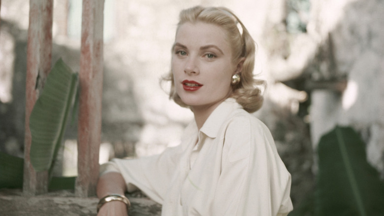 Grace Kelly avec du rouge à lèvres dehors dans un jardin