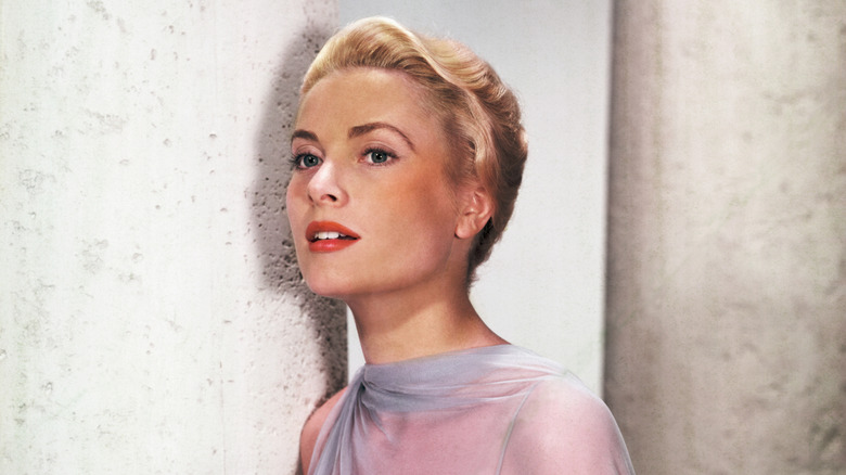 Grace Kelly dans une robe bleue appuyée contre un pilier