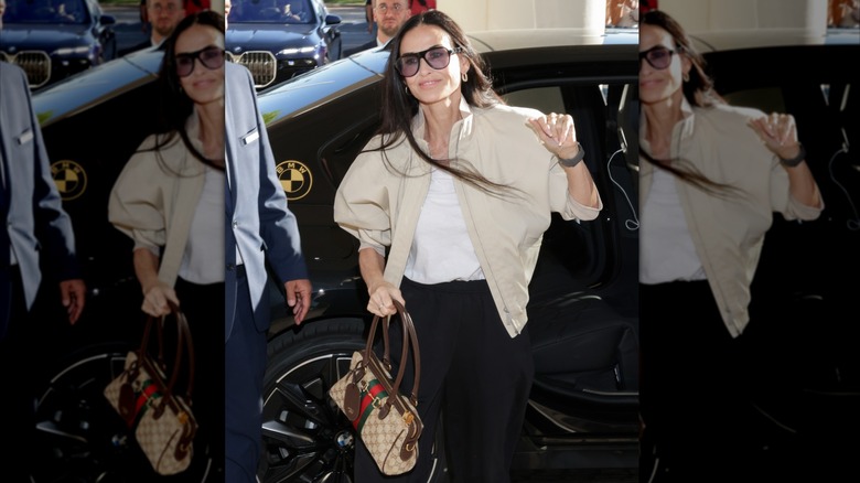Demi Moore sort d'une voiture dans une tenue décontractée avec un pantalon noir, une chemise blanche et une veste marron clair