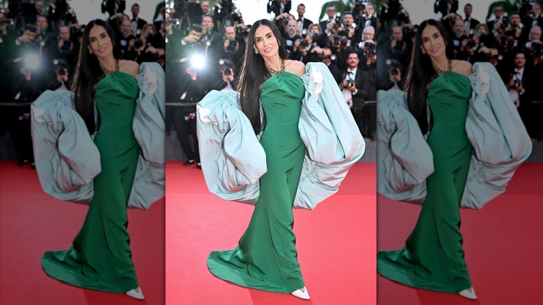 Demi Moore sur le tapis rouge dans une robe verte avec une volumineuse écharpe bleue