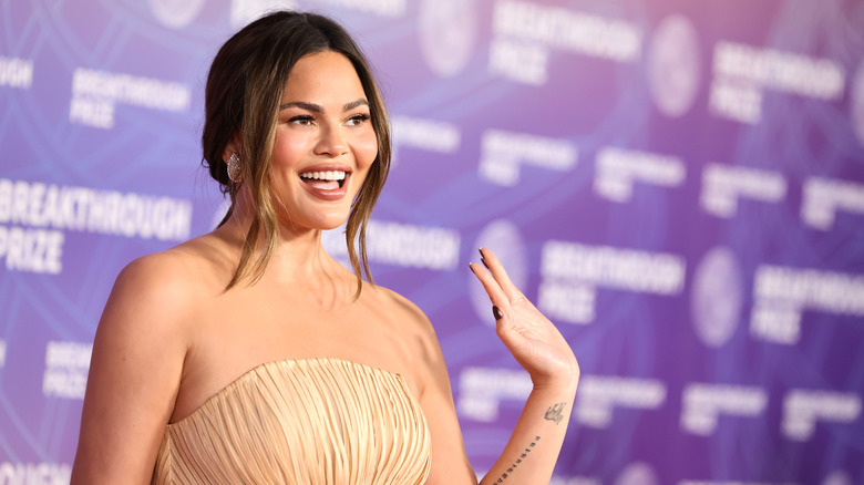 Chrissy Teigen saluant sur le tapis rouge