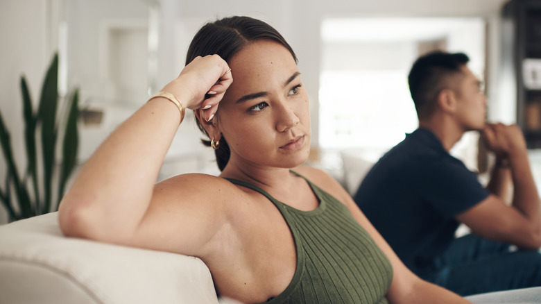 Couple frustré assis dans le salon à la maison