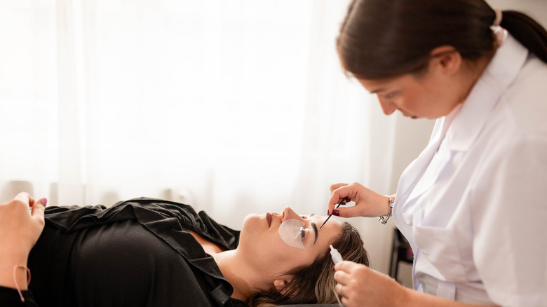 Des femmes se font teinter les sourcils par un expert