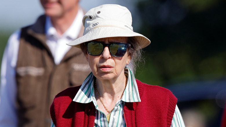 La princesse Anne portant un chapeau bob et un gilet rouge lors d'un événement
