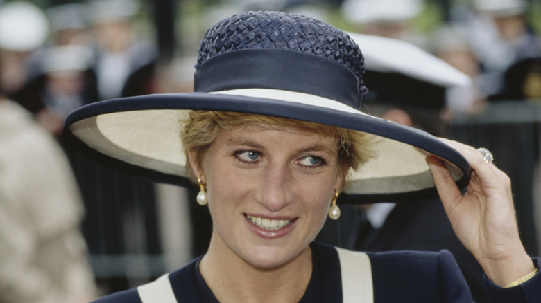 Princesse Diana avec un chapeau de paille bleu et blanc