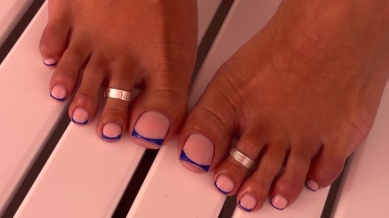 Pieds de femme avec une manucure micro-French tip bleu foncé