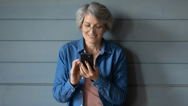 Vue d'une femme de dos qui regarde une application de rencontres sur un téléphone