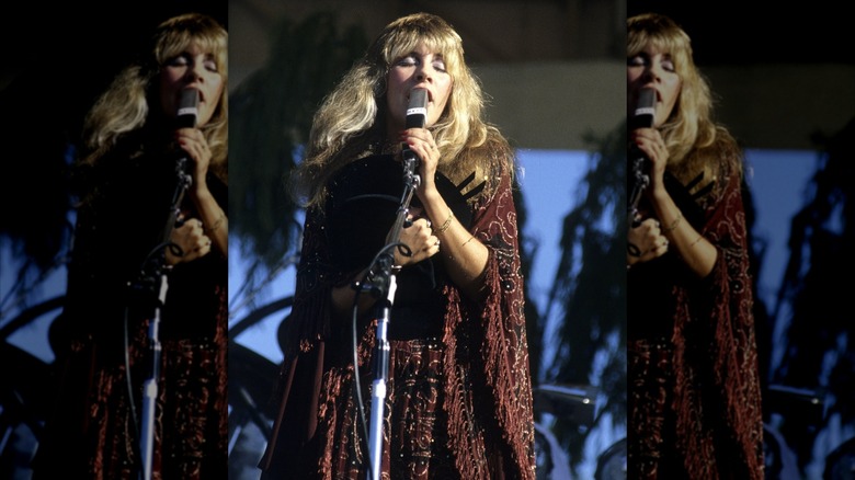 Stevie Nicks chante sur scène dans un châle bordeaux brodé