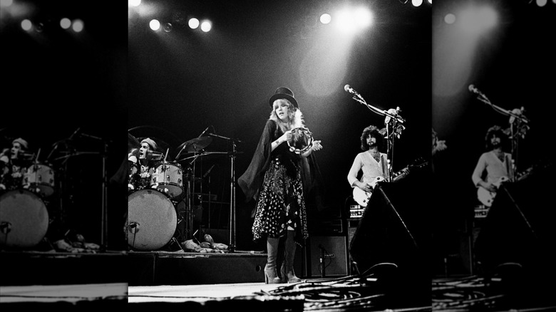 Stevie Nicks se produit sur scène avec un tambourin, un haut-de-forme et des bottes à plateforme.